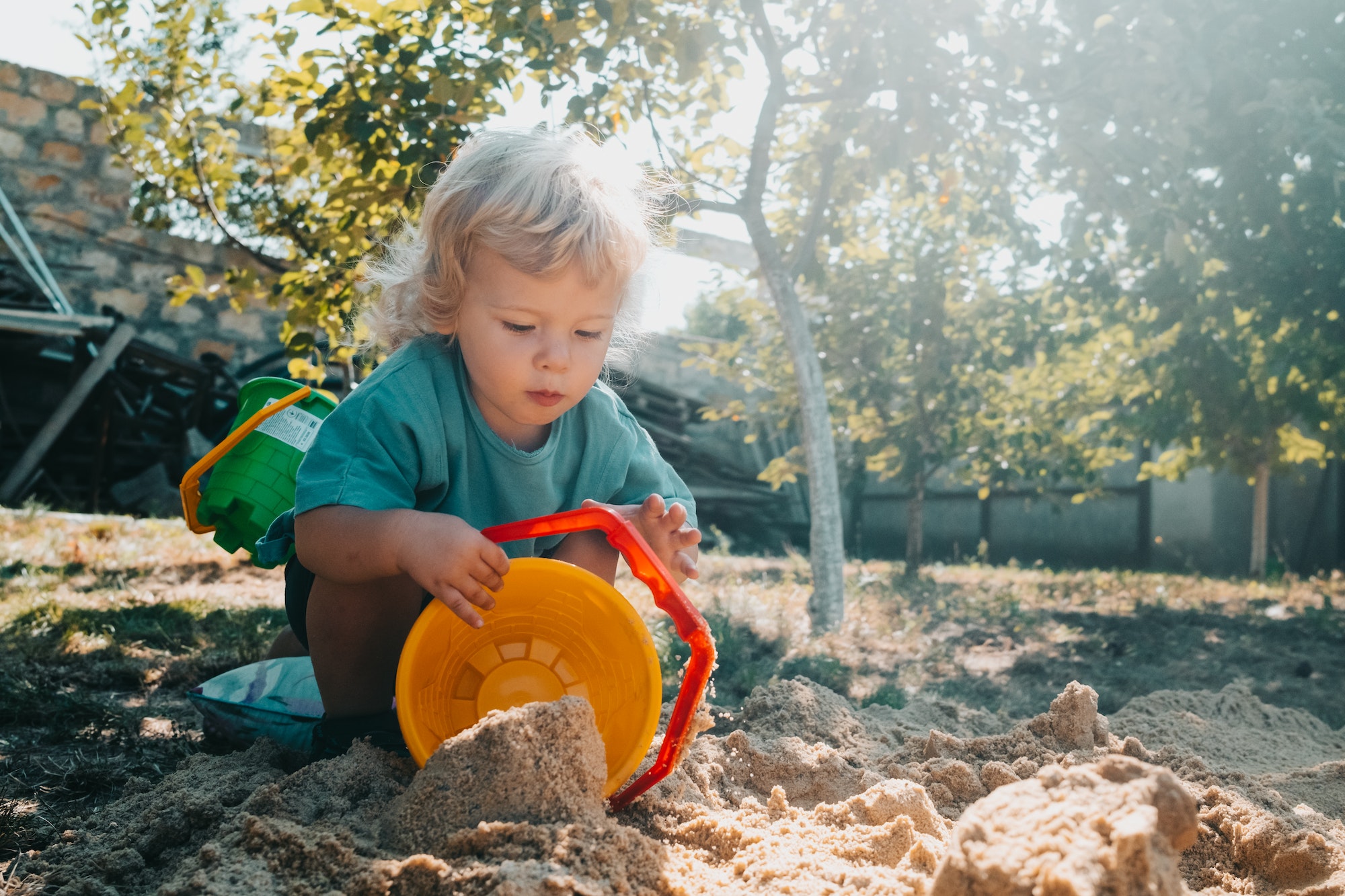 Baby boy builds a sand bead in sandbox